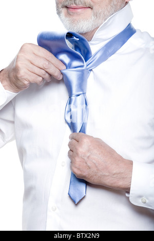 windsor necktie lesson doing by an handsome man senior getting dressed on isolated white background Stock Photo