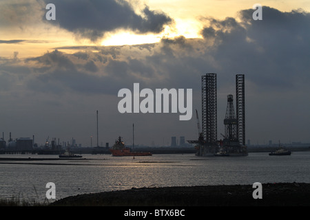 Old north sea drilling platform being towed into Teesport by ocean going and small tugs to be scrapped. Stock Photo