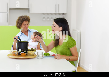 family eating meat fondue at home Stock Photo