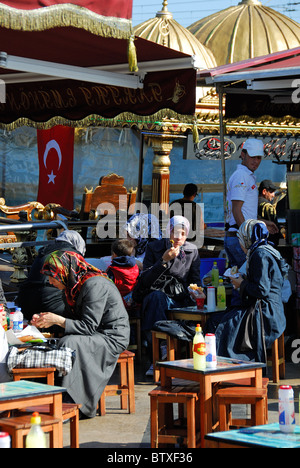 ISTANBUL, TURKEY. Turkish girls eating balik ekmek (fish sandwiches) by the ferry terminal in Eminonu district. 2010. Stock Photo