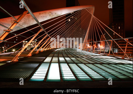 Night time, low angle-of view, image of the Zubizuri bridge across the Nervion River in Bilbao, Spain. Stock Photo