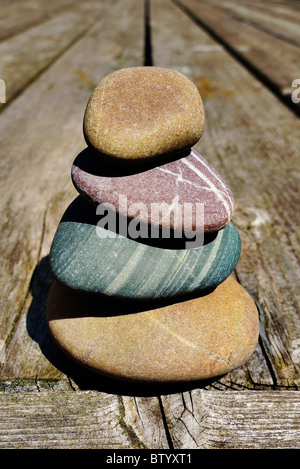 Stacked smooth stones on a wooden deck.