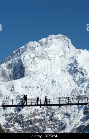 Family of hikers on Hooker River Footbridge & Mt Sefton, Aoraki / Mt Cook National Park, Canterbury, South Island, New Zealand Stock Photo