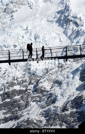 Hiker on Hooker River Footbridge & Mt Sefton, Aoraki / Mt Cook National Park, Canterbury, South Island, New Zealand Stock Photo