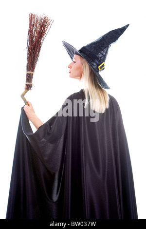 Portrait of young female in black hat and black clothing holding broom Stock Photo