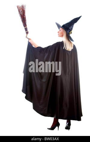 Portrait of young female in black hat and black clothing holding broom Stock Photo