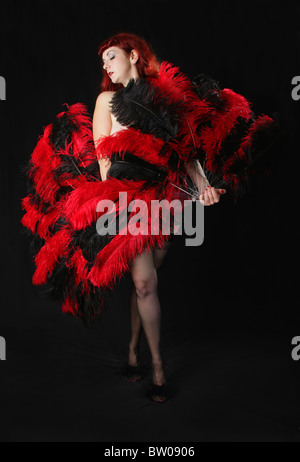 Burlesque Performer Dancing with Red and Black Fans Stock Photo