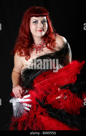 Burlesque Performer Dancing with Red and Black Fans Stock Photo
