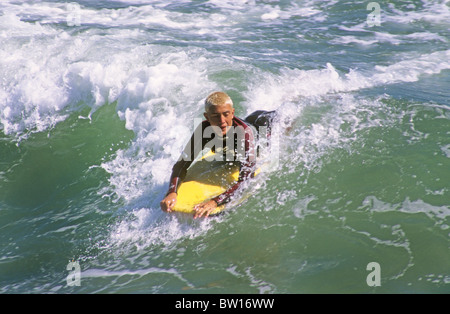 surfer board wave surf ride bellyboard paddle skim splash water Pacific ocean sea beach California sun Stock Photo