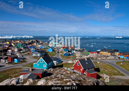 Icebergs and colourful houses in the town Ilulissat / Jakobshavn, Disko-Bay, Greenland Stock Photo