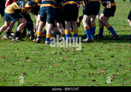 young boys playing rugby in a scrum in an outdoor playing field in ...