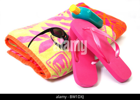 Beach towel, flip flops, sunglasses, and sunscreen isolated on white background. Stock Photo