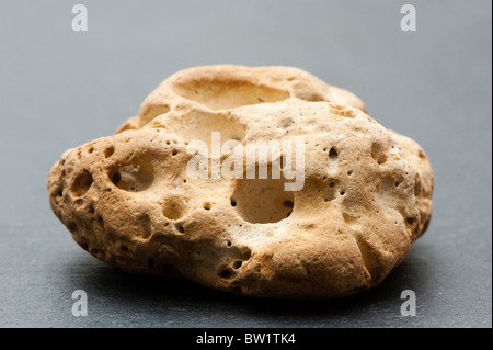 Porous stone on grey slate Stock Photo