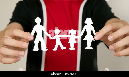 Child with black and red shirts is holding family figures made from paper Stock Photo