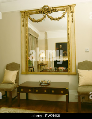 Large ornate gilt mirror above fireplace in cosy panelled country Stock ...