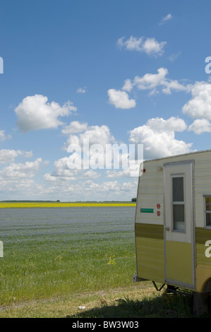 Camper trailer parked at side of alfalfa and canola field near winnipeg, manitoba, canada Stock Photo