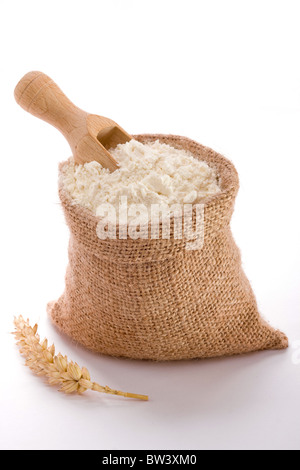 Flour in burlap sack and wooden spoon Stock Photo