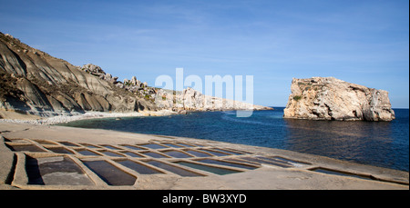 Salt pans cut in the limestone shelf at Il-Gebla Tal-Halfa, a scenic bay with an offshore isle in Qala point in Gozo in Malta.