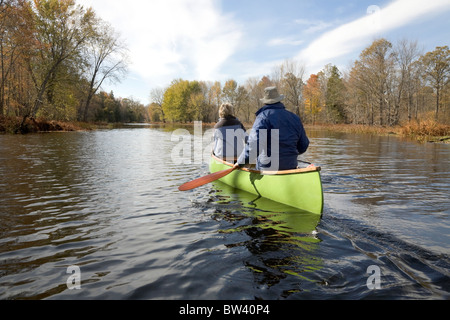 Senior couple canoeing on the Moira River in autumn, Hastings County, Ontario, Canada Stock Photo
