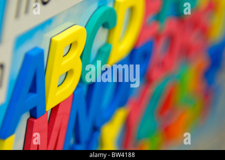 Multicolored refrigerator magnets that are letters of the alphabet are aligned. Stock Photo