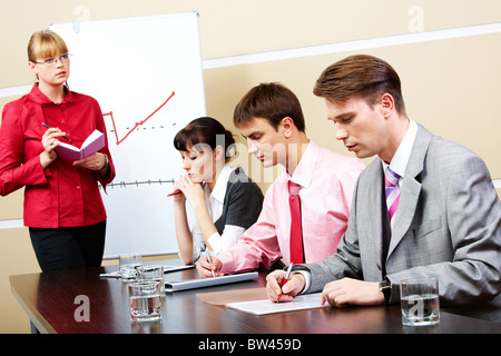 Image of smart teacher looking at students in workshop Stock Photo