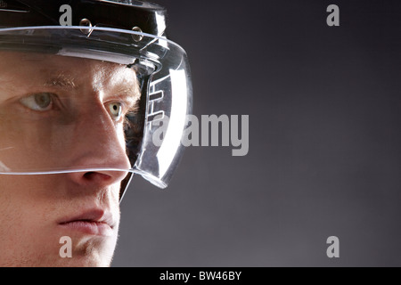 Face of sportsman in protective helmet looking seriously forwards Stock Photo