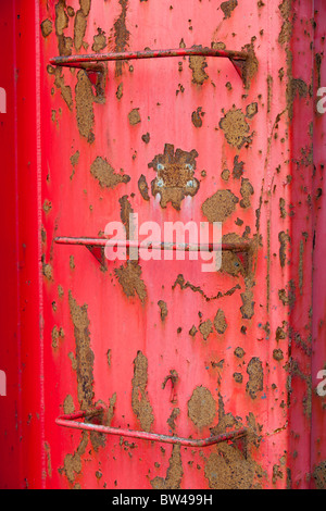 Metal ladders on red container wall Stock Photo