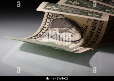 Money. US Dollars on a glass surface in a floodlit. Copy-space. Shallow DOF.