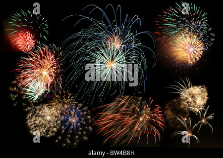 Multiple bursts of multicolored fireworks fill the frame against a black background Stock Photo