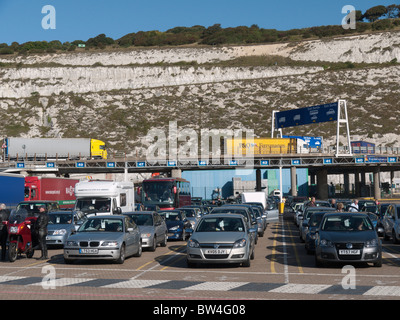 Cars queue to board at Dover ferry port as arriving lorries leave the docks Stock Photo