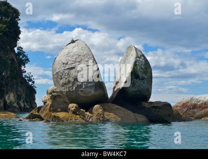 A unique rock formation known as Split Apple Rock surfaces out of the Tasman Sea in Abel Tasman National Park, New Zealand. Stock Photo