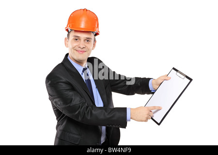 A young foreman wearing helmet and pointing on a clipboard Stock Photo