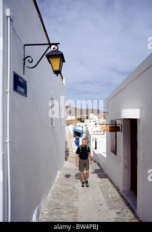 Visitor walking on a typical narrow street of Ano Syros, on the Greek Cyclade island of Syros. Stock Photo