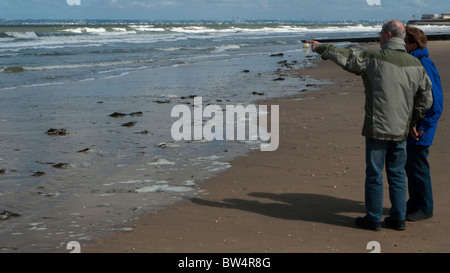 Middle-aged couple walking on beach at Trouville, Normandy France Stock Photo