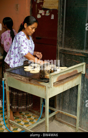 Maya woman cooking corn tortillas on a grill in Coban, Alta Verapaz, Guatemala Stock Photo