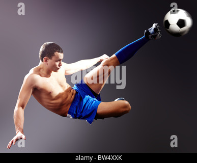 Professional sportsman kicks soccer ball Stock Photo