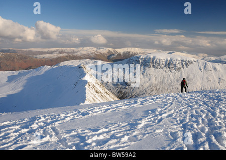 Walker on Helvellyn looking out over Striding Edge towards St Sunday Crag. Winter mountain view in the English Lake District Stock Photo