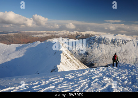 Walker on Helvellyn looking out over Striding Edge towards St Sunday Crag. Winter mountain view in the English Lake District Stock Photo