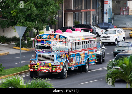 A uniquely painted colorful bus speeds down the road in Panama City, Panama. Stock Photo