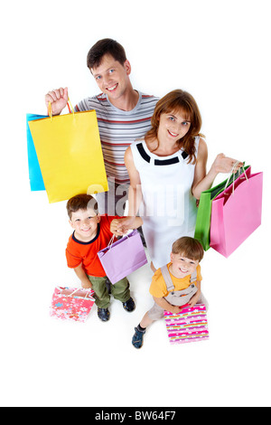 Photo of friendly parents and siblings with bags smiling at camera Stock Photo