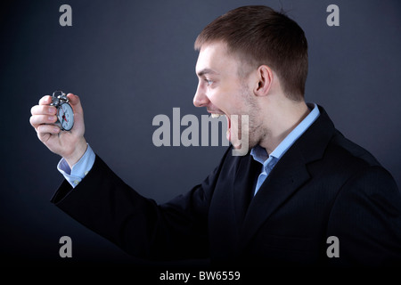Portrait of young man looking at clock and shouting Stock Photo
