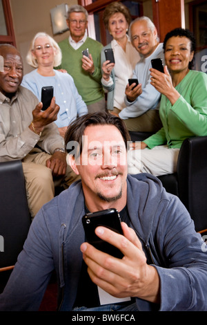 Man with group of seniors using modern technology Stock Photo