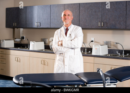 Portrait of doctor in medical office, arms folded Stock Photo