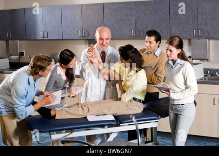 Medical school professor teaching students, examining patient Stock Photo