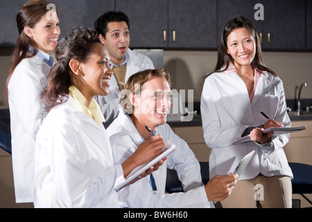 Medical students in class taking notes, smiling Stock Photo