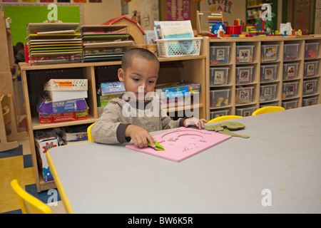 Preschool boy doing a puzzle in the classroom Stock Photo