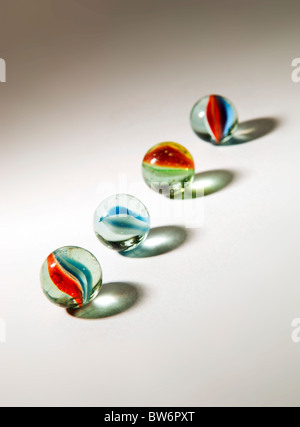Brightly colored marbles in different shades with deliberately long shadows Stock Photo