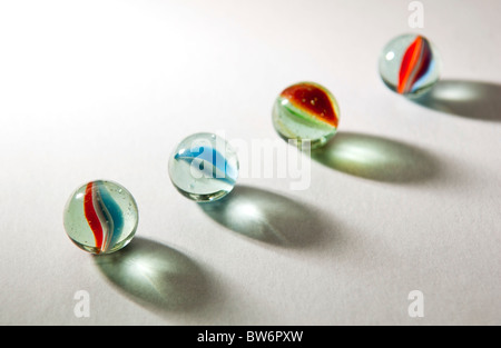Brightly colored marbles in different shades with deliberately long shadows Stock Photo