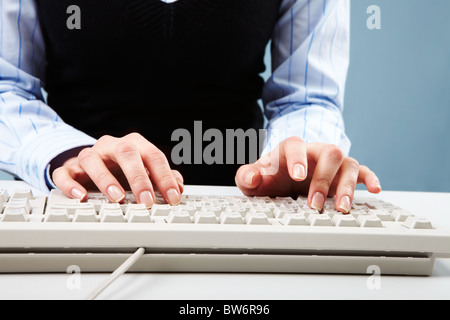 Photo of female hands over white keyboard pushing its buttons during work Stock Photo