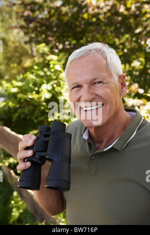 Senior man holding binoculars Stock Photo